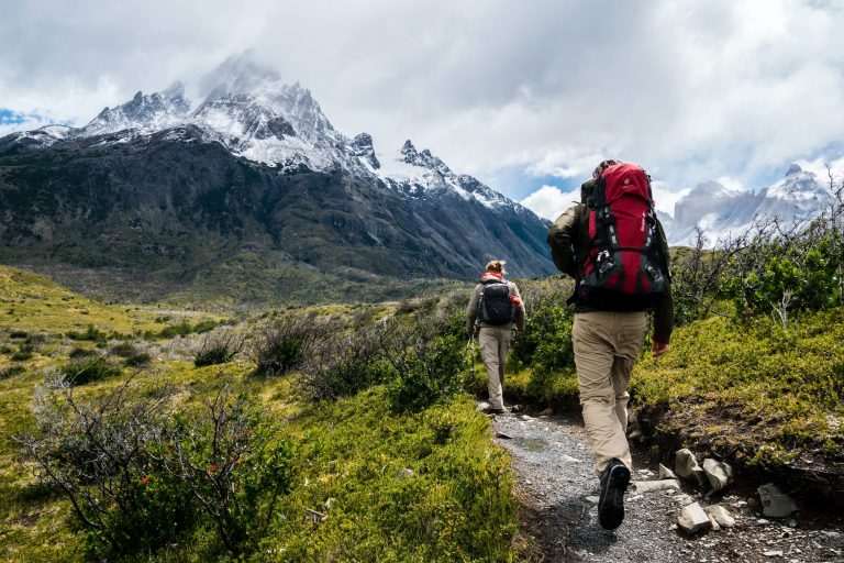 Zwei Wanderer die während Yoga Retreat in den Bergen auf einem Wanderweg in den Bergen laufen
